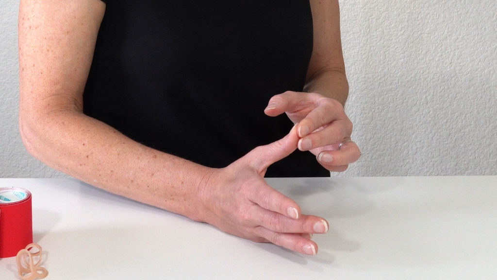 Image shows applying isometric contraction to tip of thumb using fingers from other hand.